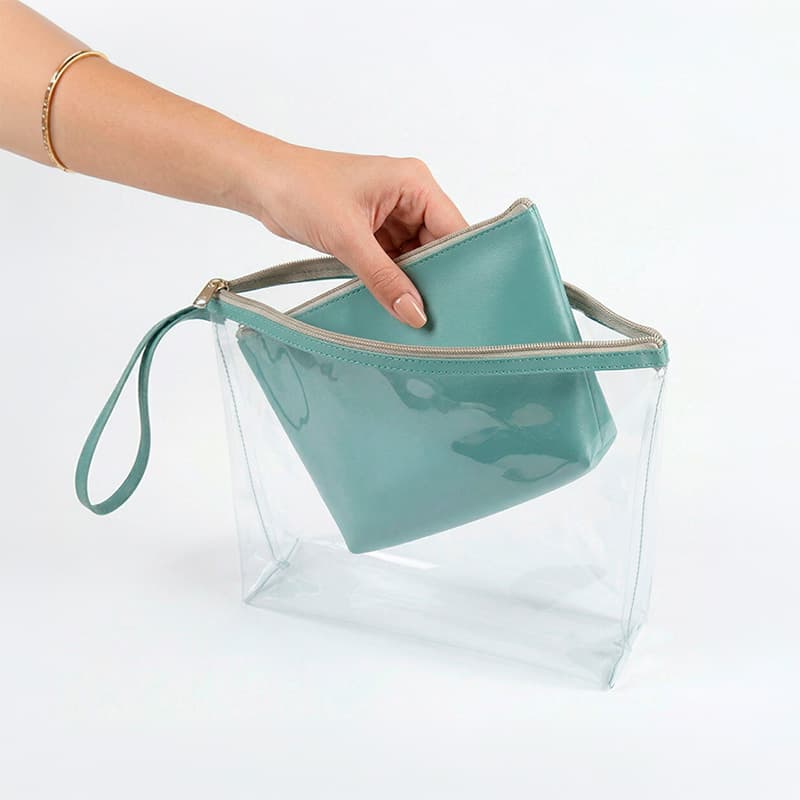 uma mão feminina retirando uma necessaire de dentro de outra